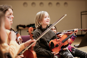 Kinder spielen Violine bei der Orchesterprobe